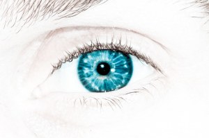 Close-up of a human eye with vibrant blue iris and eyelashes.